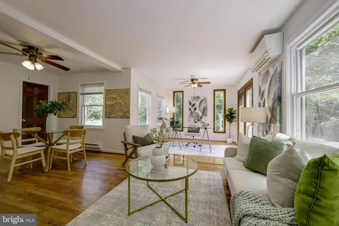 a living room with furniture large window and wooden floor