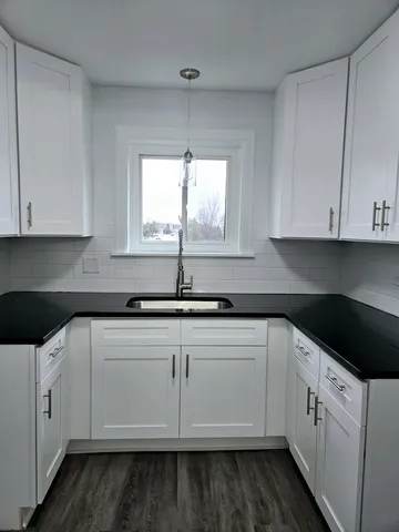 a kitchen with white cabinets white appliances sink and dishwasher