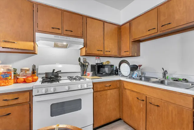 a kitchen with stainless steel appliances granite countertop a sink stove and cabinets