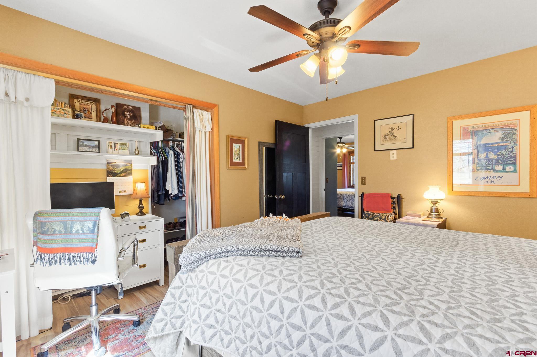 13720 6000th Road Montrose, CO 81403 - Photo 16 of 36 a bedroom with a bed and a chandelier