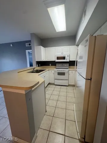 a kitchen with a sink a stove a refrigerator and cabinets