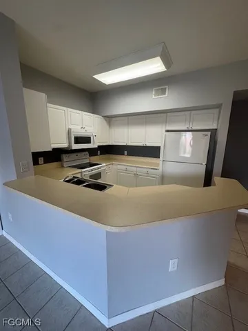 a kitchen with kitchen island cabinets and refrigerator