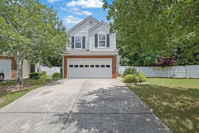 a view of a house with a yard and a garage
