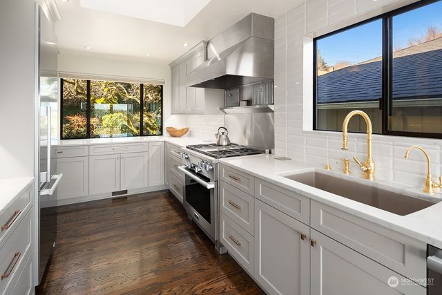 a kitchen with stainless steel appliances a sink stove and cabinets