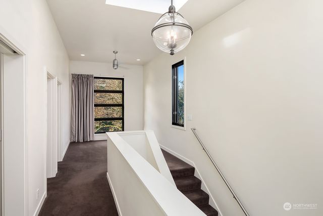 a view of a hallway with wooden floor and staircase