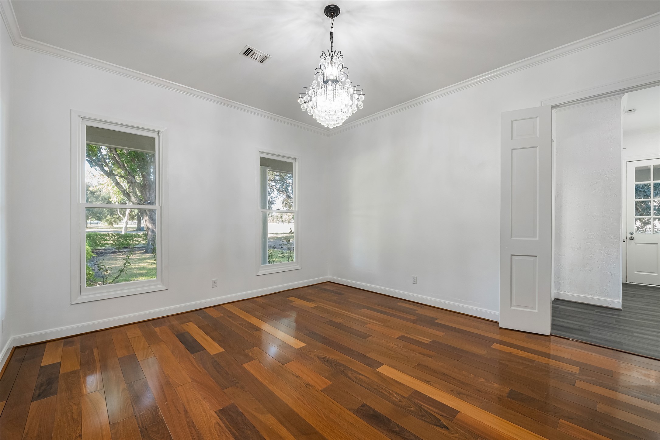 4610 Lea Lane Fulshear, TX 77406 - Photo 8 of 50 a view of an empty room with wooden floor and a window
