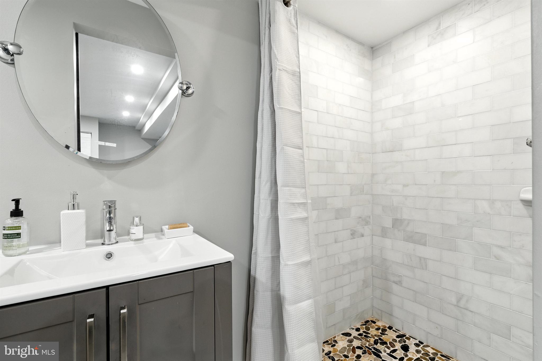 21804 Goshen School Road Gaithersburg, MD 20882 - Photo 19 of 37 a bathroom with a sink a mirror and shower