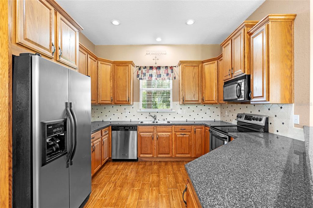 4405 North Wilder Road Plant City, FL 33565 - Photo 11 of 78 a kitchen with stainless steel appliances granite countertop a sink a stove and a refrigerator