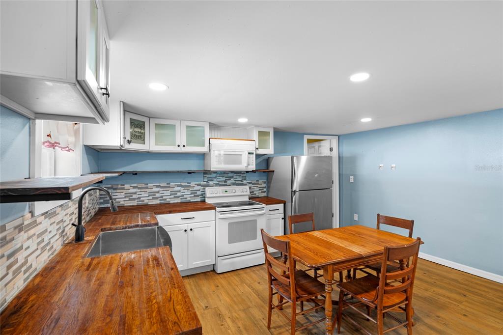 4405 North Wilder Road Plant City, FL 33565 - Photo 61 of 78 a kitchen with stainless steel appliances granite countertop a stove top oven a sink dishwasher and a refrigerator with wooden floor