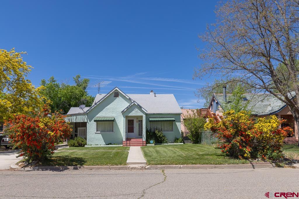 a front view of a house with a garden and trees