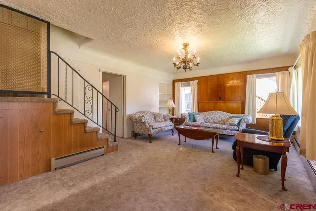 a living room with furniture fireplace and a large window