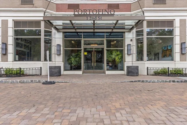 a living room with stainless steel appliances kitchen island granite countertop a sink and a view of living room