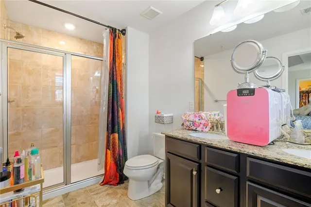 a bathroom with a granite countertop sink mirror vanity and toilet
