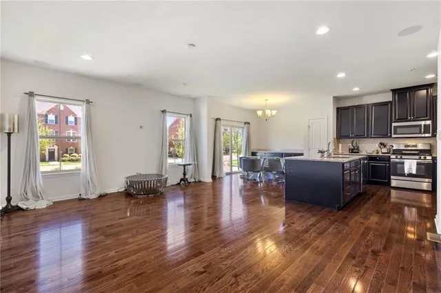 a living room with furniture kitchen view and a wooden floor