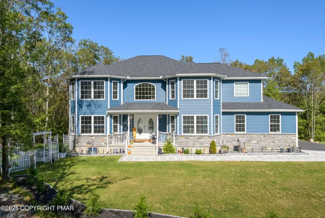a front view of a house with yard and green space