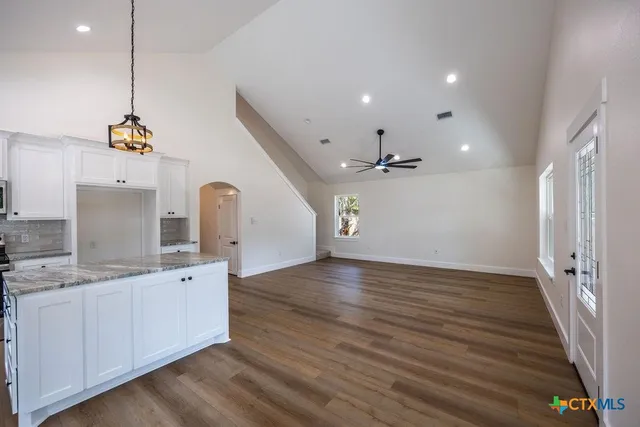 a view of a kitchen with a sink and dishwasher with wooden floor