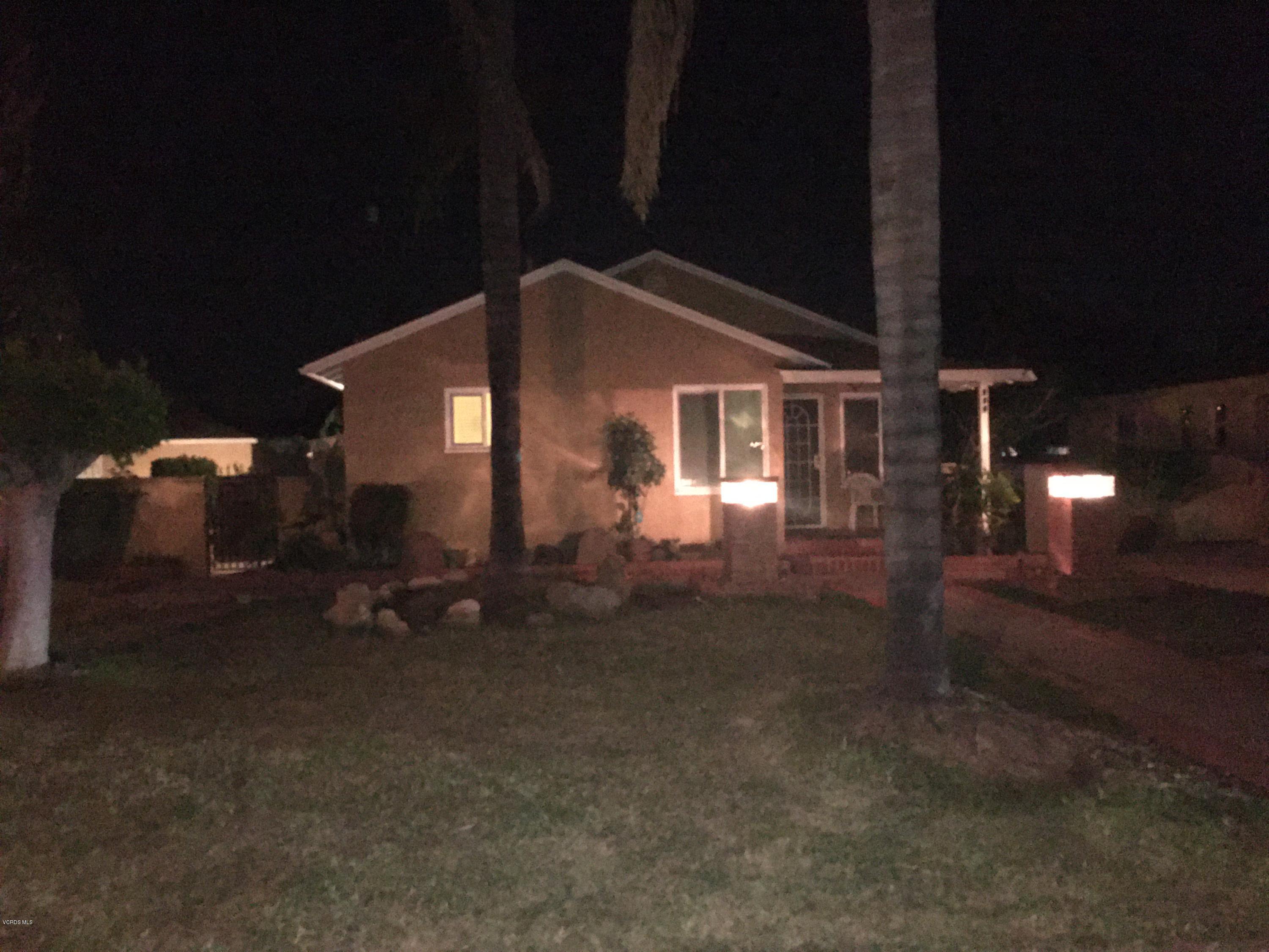 a backyard of a house with table and chairs