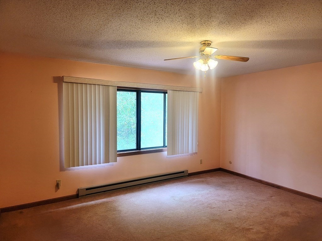 383 Rondeau Street Palmer, MA 01069 - Photo 9 of 14 an empty room with a chandelier fan and windows