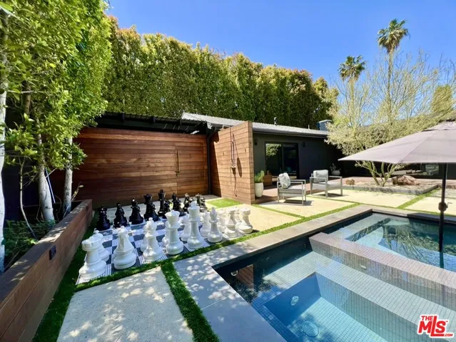 a view of a swimming pool with a table and chairs under an umbrella