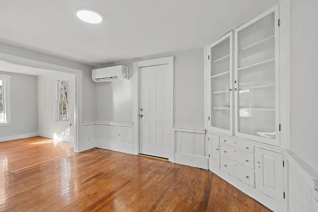 an empty room with cabinet and wooden door