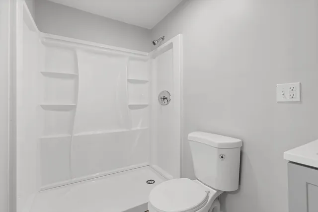 a white toilet sitting next to a bath tub