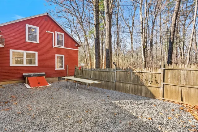 a backyard of a house with table and chairs