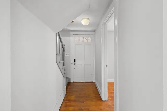 a view of a hallway with wooden floor and entryway