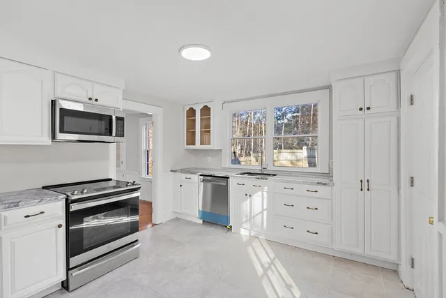 a kitchen with stainless steel appliances a stove sink and microwave