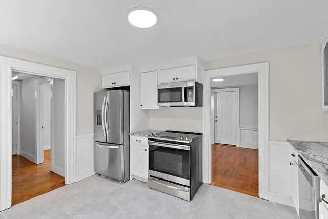 a kitchen with stainless steel appliances granite countertop a refrigerator and a stove top oven