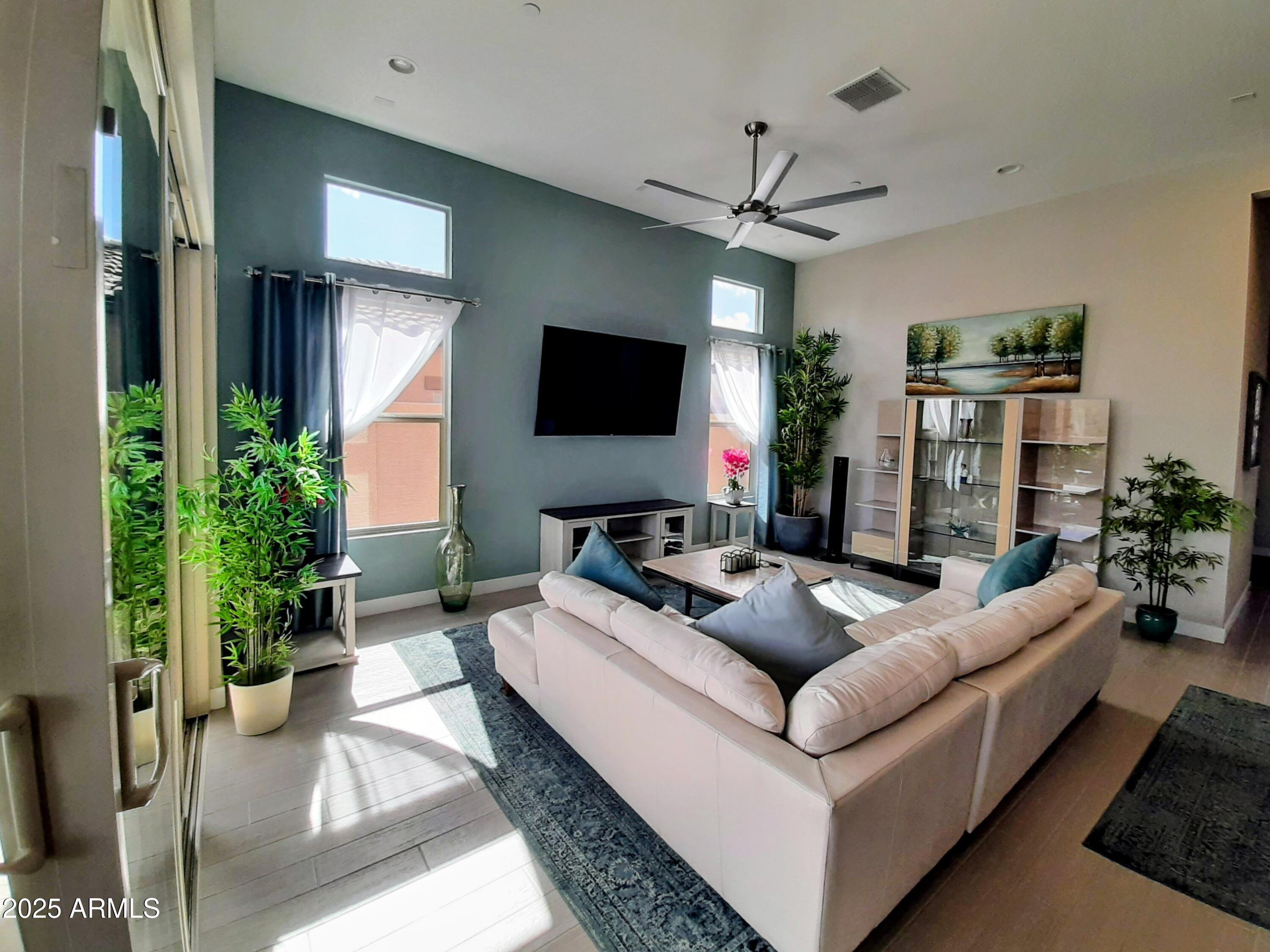18828 East Blue Sky Drive Rio Verde, AZ 85263 - Photo 10 of 21 a living room with furniture a chandelier and a flat screen tv