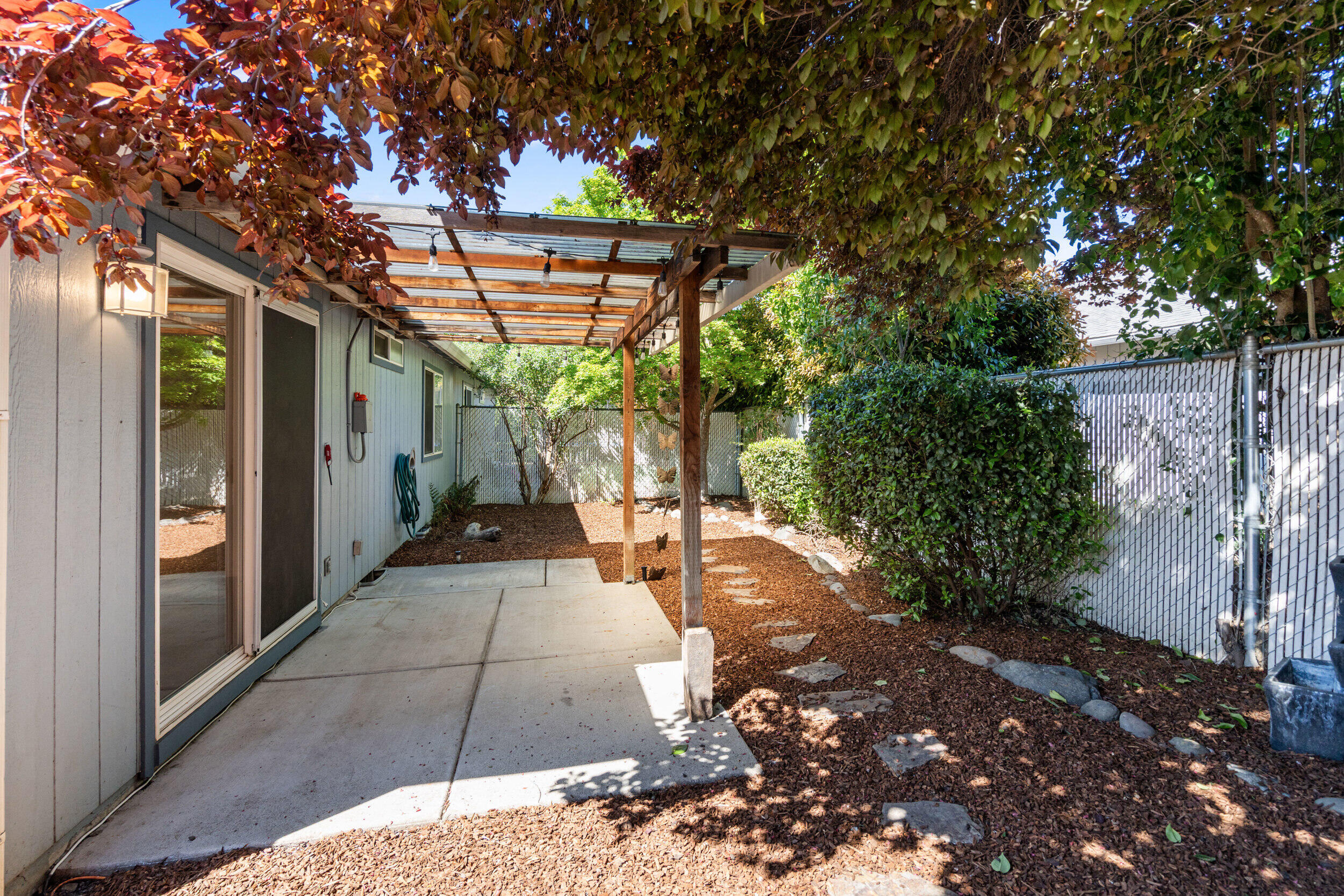 943 Hopkins Road Central Point, OR 97502 - Photo 17 of 21 a view of a patio with table and chairs potted plants and large tree