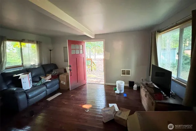 a living room with furniture a flat screen tv and a large window