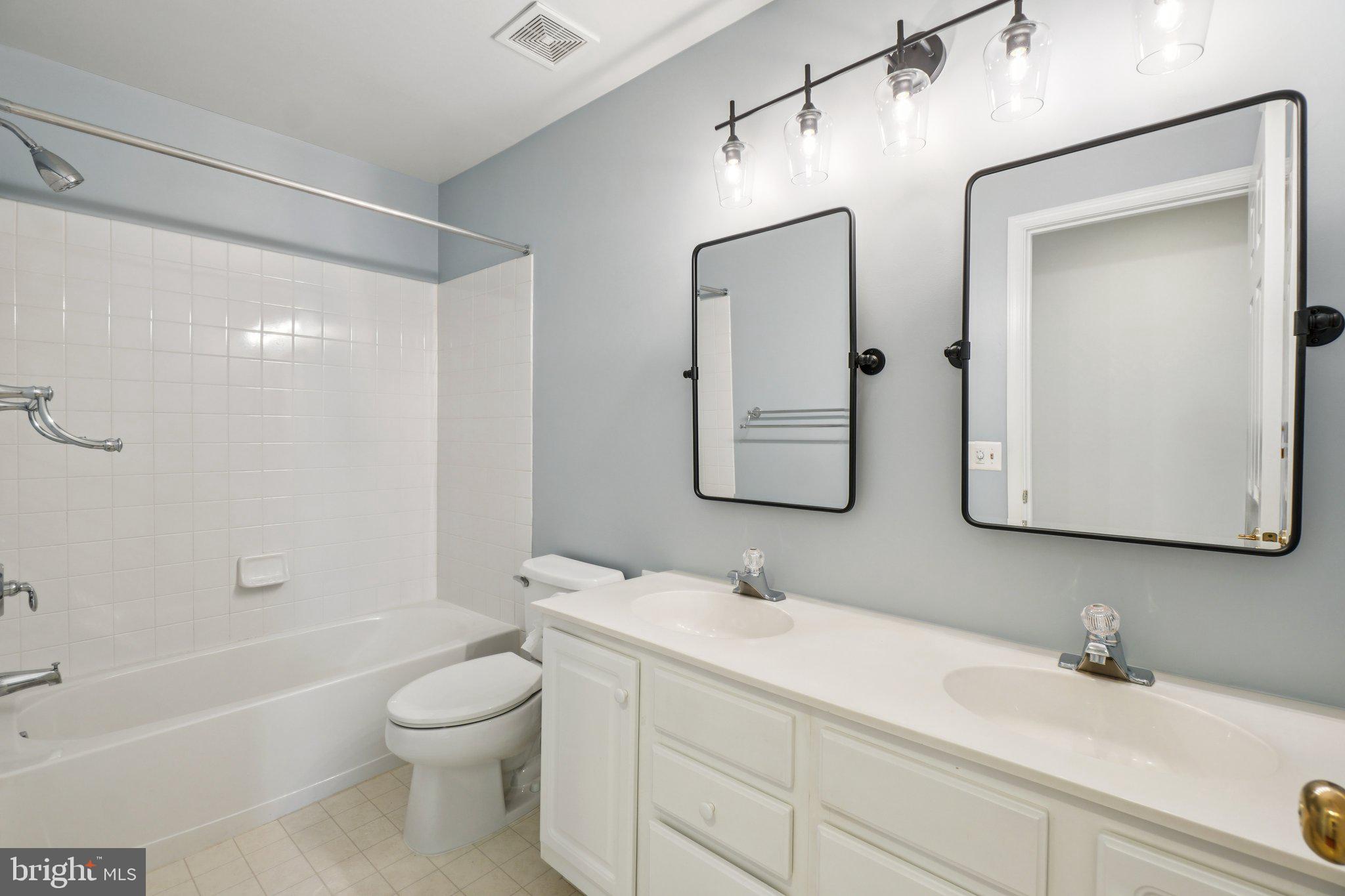 12513 Fox View Way Reston, VA 20191 - Photo 15 of 39 a bathroom with a toilet a sink a mirror a bathtub and vanity