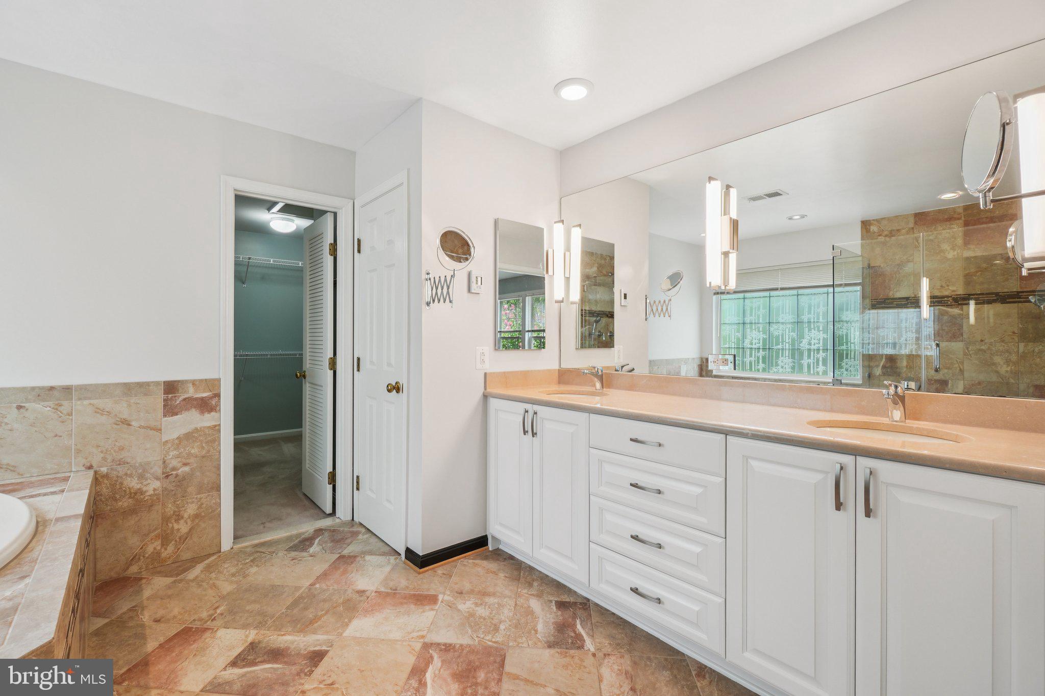 12513 Fox View Way Reston, VA 20191 - Photo 20 of 39 a spacious bathroom with a double vanity sink a mirror and a shower