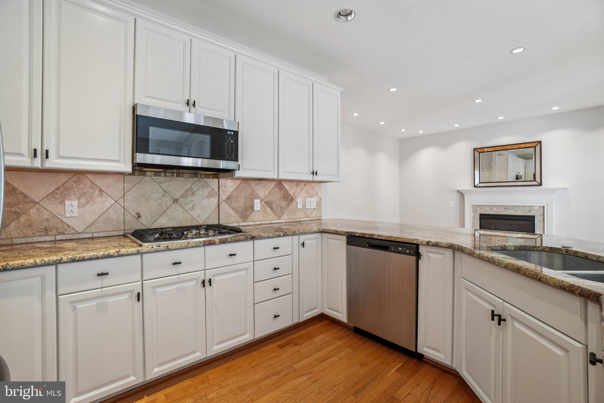 12513 Fox View Way Reston, VA 20191 - Photo 6 of 39 a kitchen with granite countertop white cabinets and stainless steel appliances