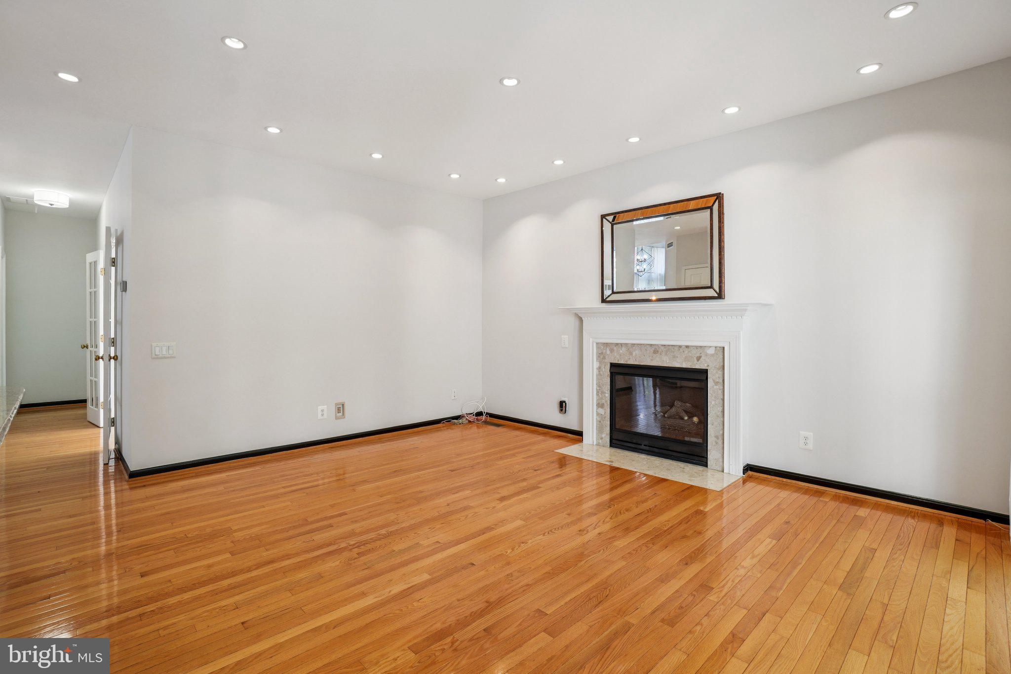 12513 Fox View Way Reston, VA 20191 - Photo 8 of 39 a view of an empty room with wooden floor and a fireplace