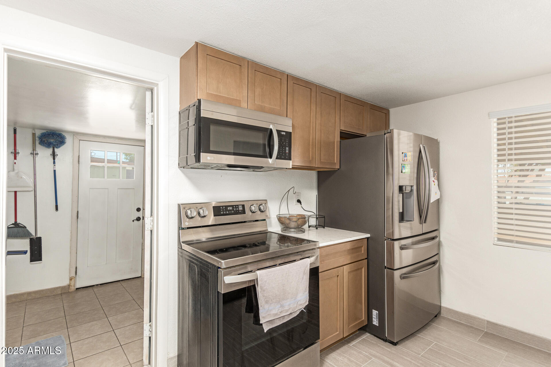 1221 East Alta Vista Road Phoenix, AZ 85042 - Photo 10 of 33 a kitchen with stainless steel appliances a stove a microwave and a refrigerator