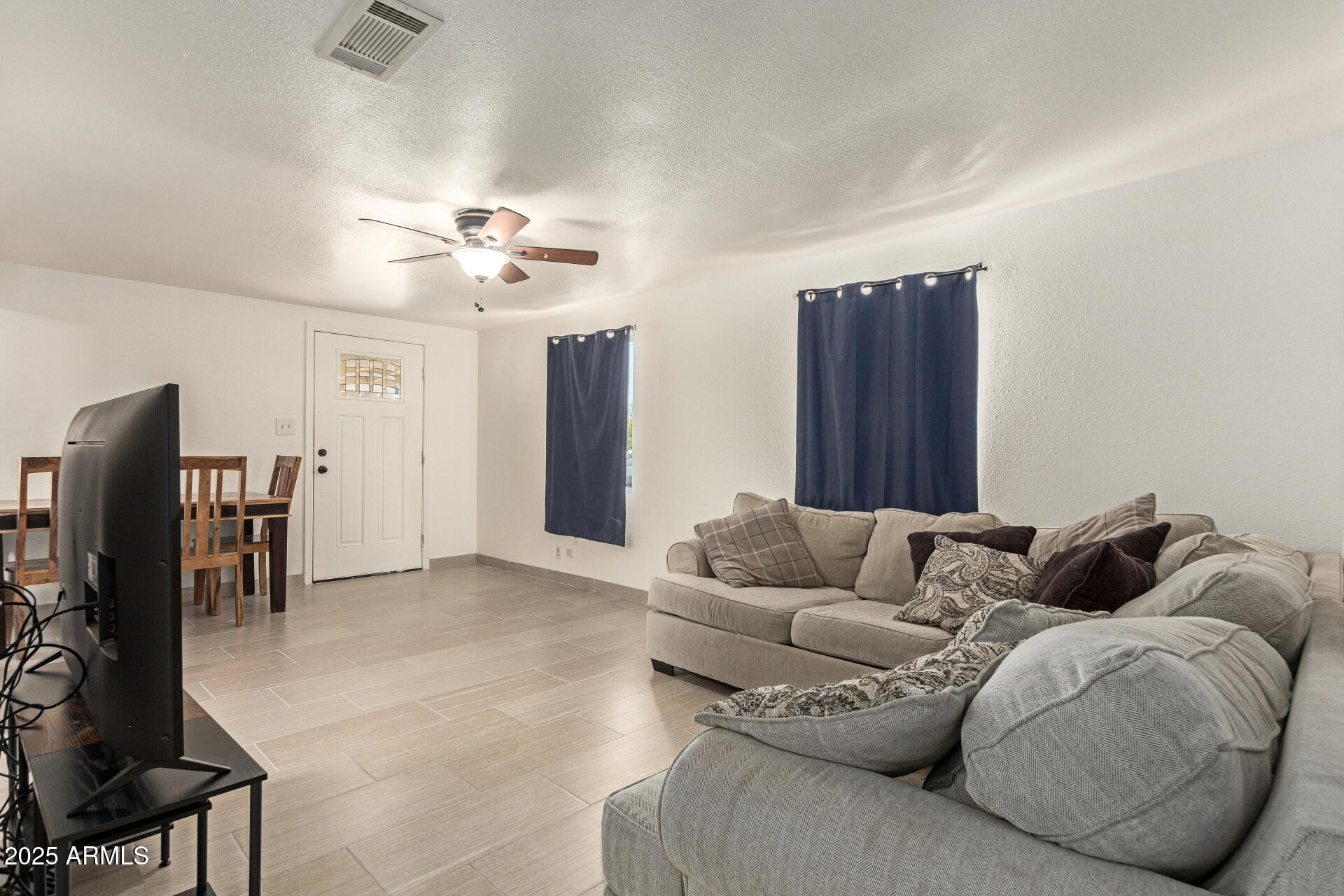 1221 East Alta Vista Road Phoenix, AZ 85042 - Photo 4 of 33 a living room with furniture and a ceiling fan