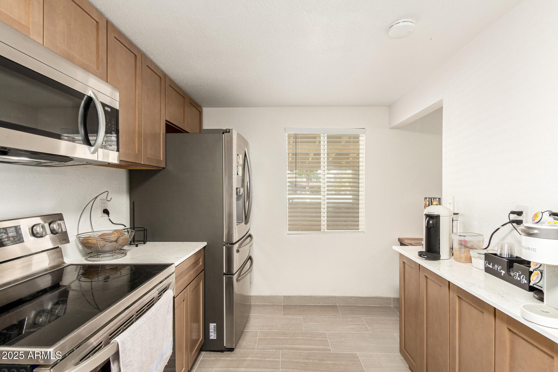 1221 East Alta Vista Road Phoenix, AZ 85042 - Photo 9 of 33 a kitchen with stainless steel appliances a stove a sink and a microwave