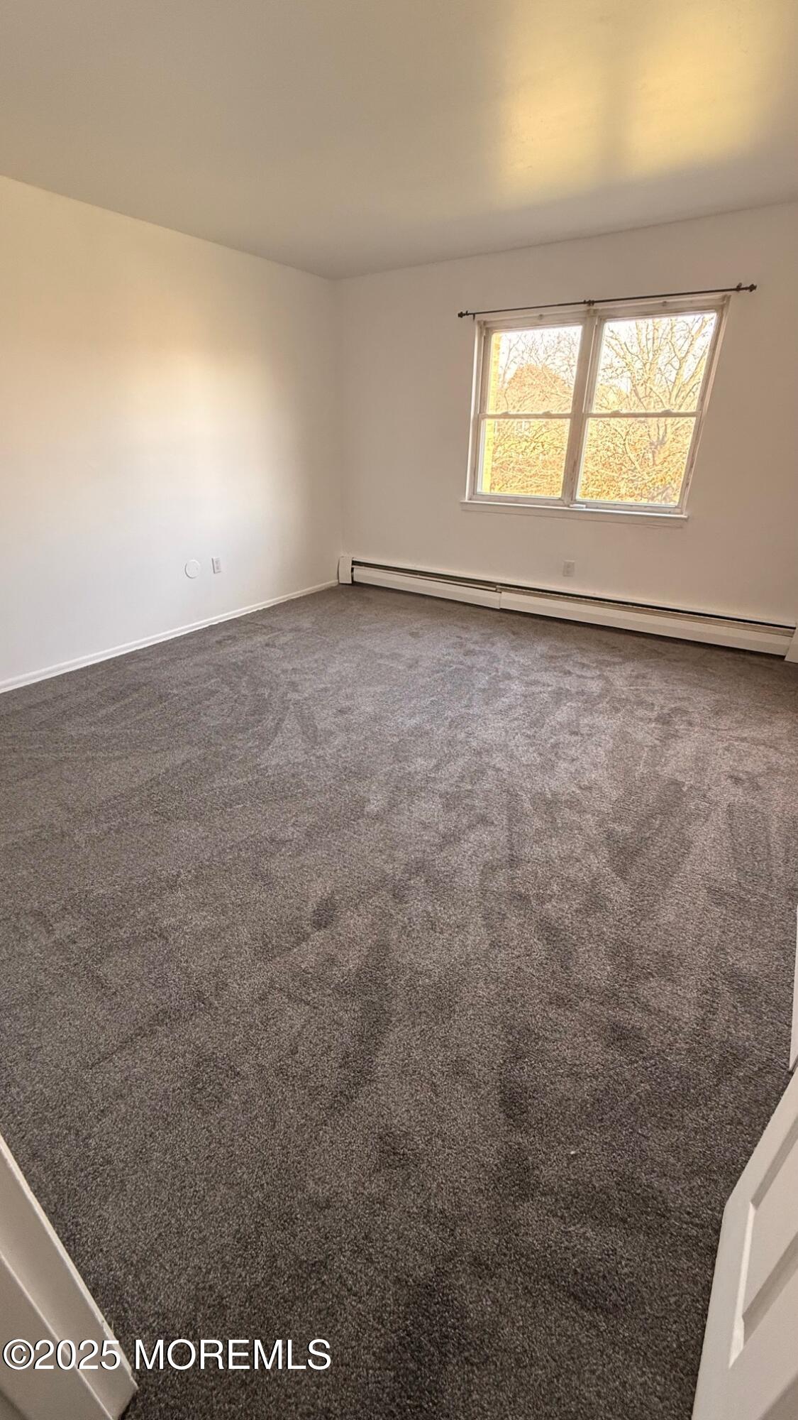 76 Manchester Court, Unit H Freehold, NJ 07728 - Photo 8 of 10 an empty room with windows