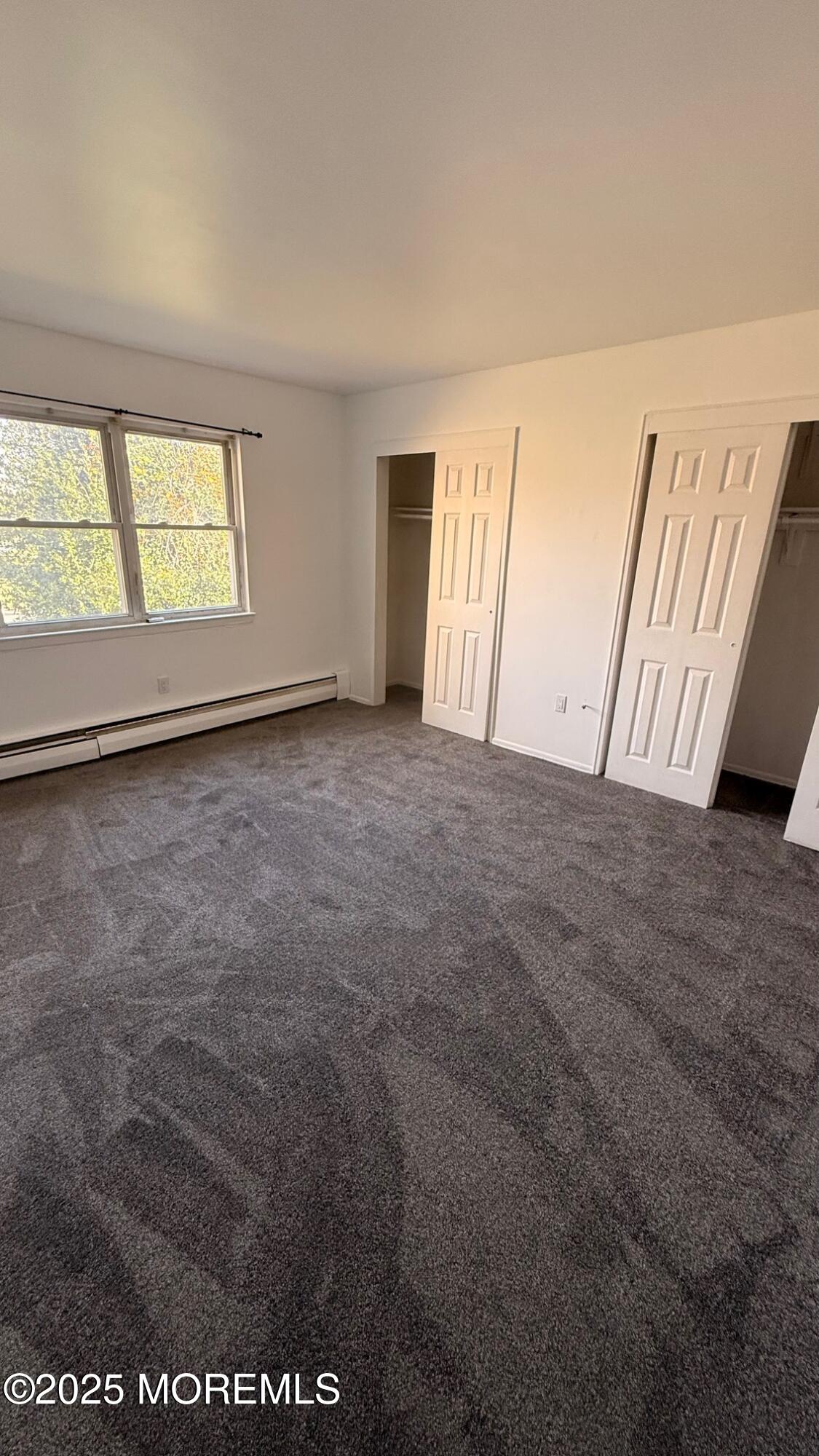 76 Manchester Court, Unit H Freehold, NJ 07728 - Photo 9 of 10 an empty room with windows