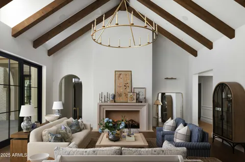 a living room with furniture a fireplace and a chandelier