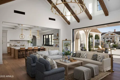 a living room with furniture kitchen view and large windows