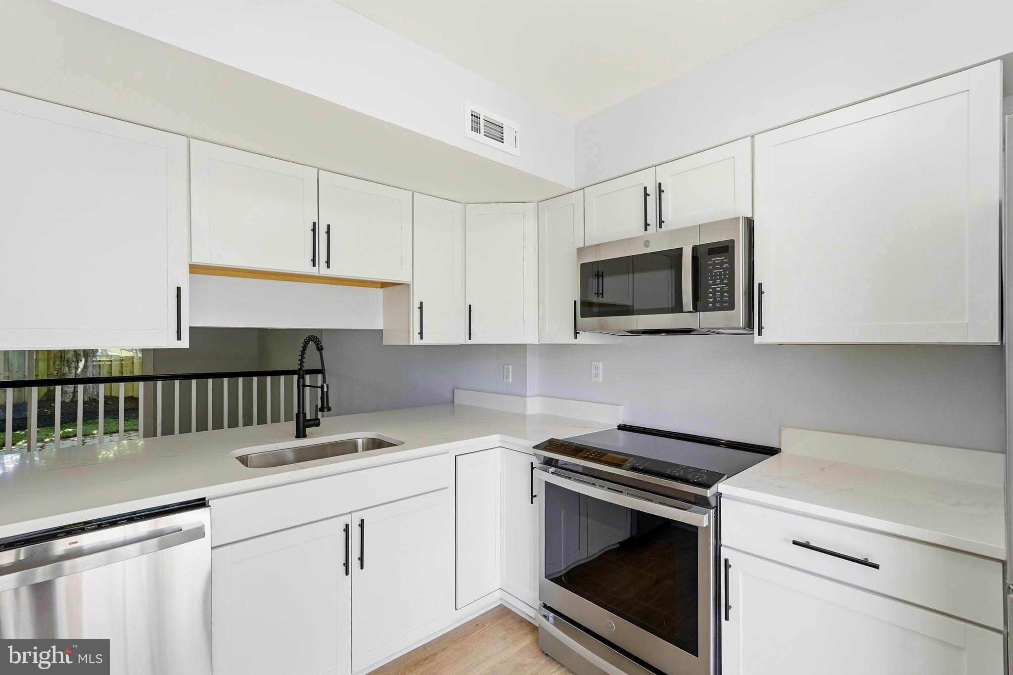 3682 Masthead Trail Triangle, VA 22172 - Photo 10 of 53 a kitchen with stainless steel appliances granite countertop a sink a stove a microwave and cabinets