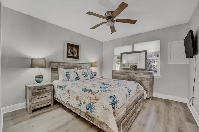 a bedroom with a bed a mirror and a flat tv screen on dresser