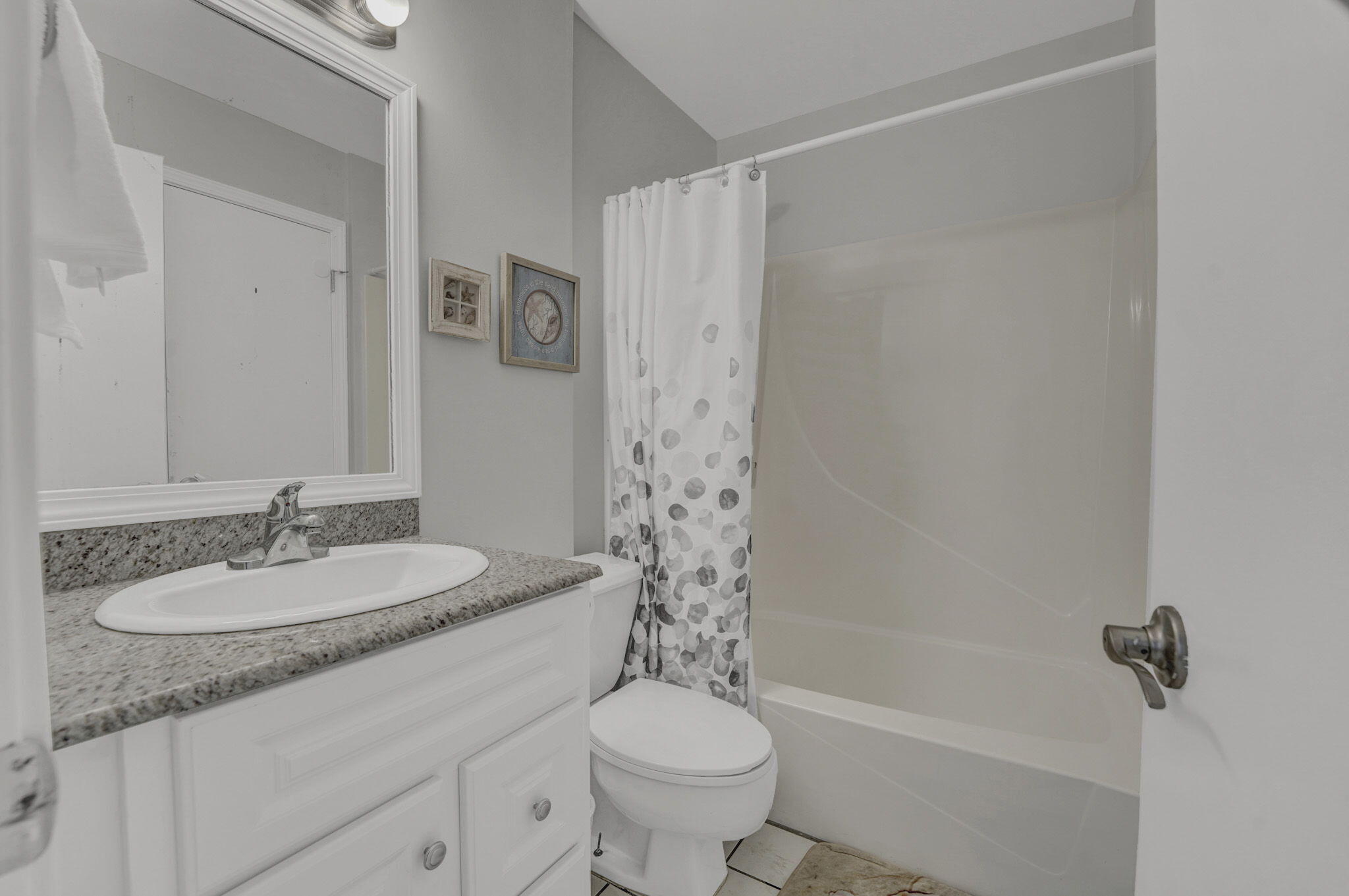 8046 East County Highway 30A Inlet Beach, FL 32461 - Photo 13 of 36 a bathroom with a granite countertop sink a toilet a mirror a shower and a bathtub