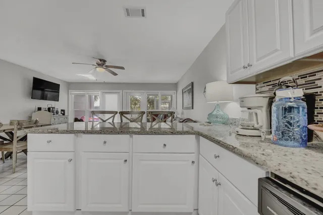 a kitchen with granite countertop white cabinets and sink