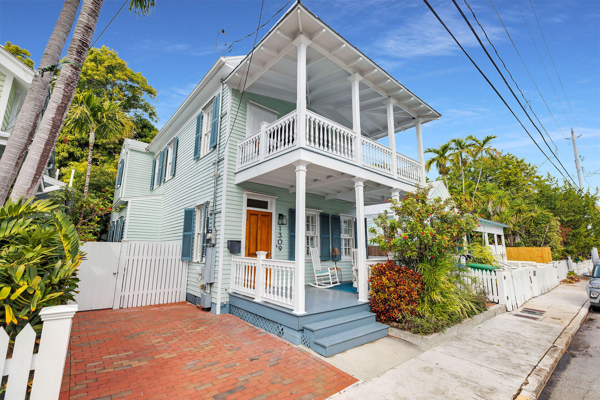 1309 Petronia Street Key West, FL 33040 - Photo 1 of 38 a view of a white house with large windows and a small yard