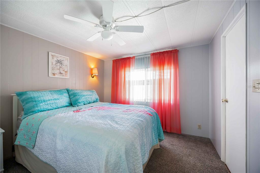 10303 Burnt Store Road, Unit 169 Punta Gorda, FL 33950 - Photo 14 of 34 a bedroom with a bed and a chandelier