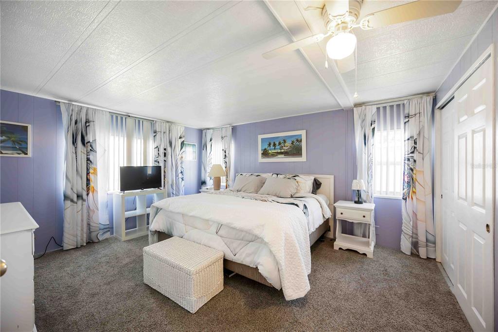 10303 Burnt Store Road, Unit 169 Punta Gorda, FL 33950 - Photo 18 of 34 a spacious bedroom with a bed and a chandelier